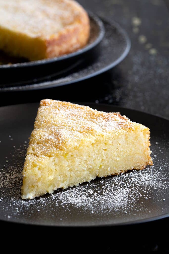 Slice of lemon ricotta cake dusted with icing sugar.