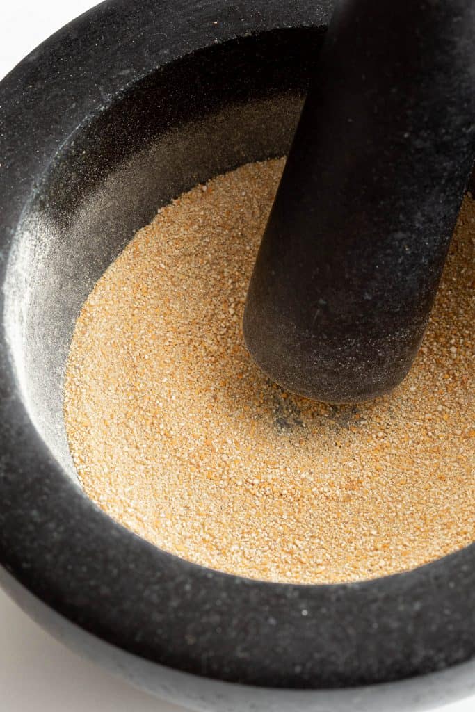 Freshly ground toasted rice powder in mortar and pestle.