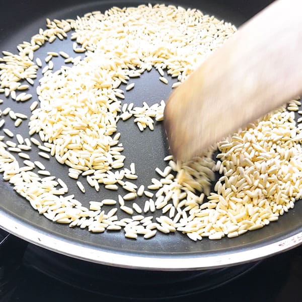 Dry roasting sticky rice in a pan.