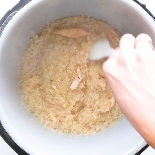 Stirring the thick chicken rice porridge in the multi-cooker.