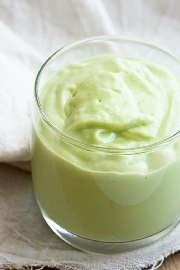 Swirled texture on top after pouring avocado smoothie into a glass to serve.