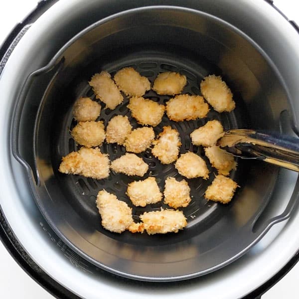 Air frying popcorn chicken pieces.