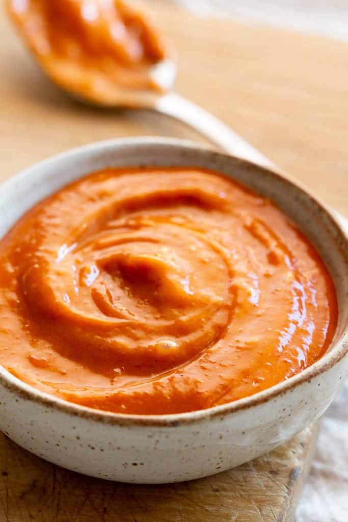 Gochujang mayonnaise in a dish with a spoon.
