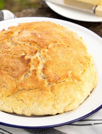 Fresh damper bread on a blue and white plate.