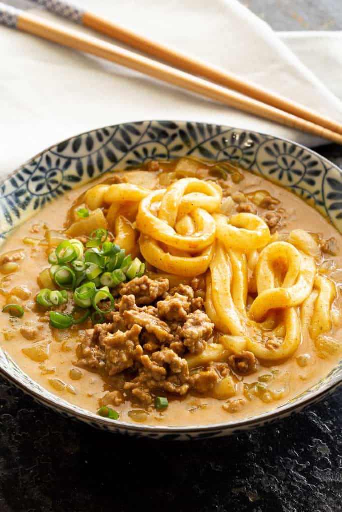 Bowl of curry udon with chopsticks.