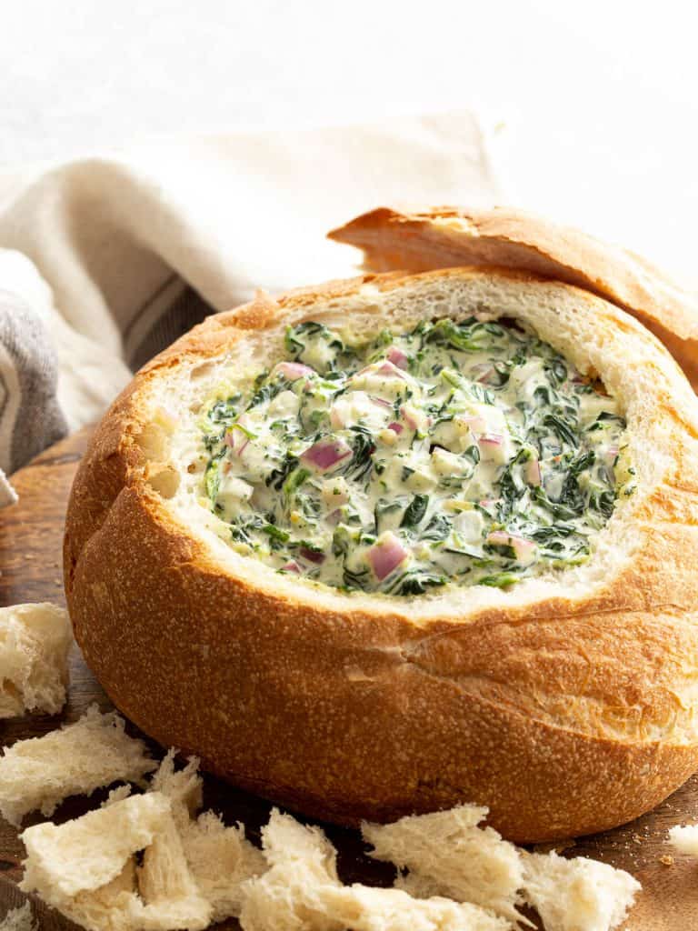 A toasted cob loaf stuffed with spinach dip.
