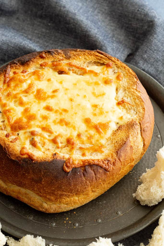 Cheese and bacon cob loaf with melted cheese on top.