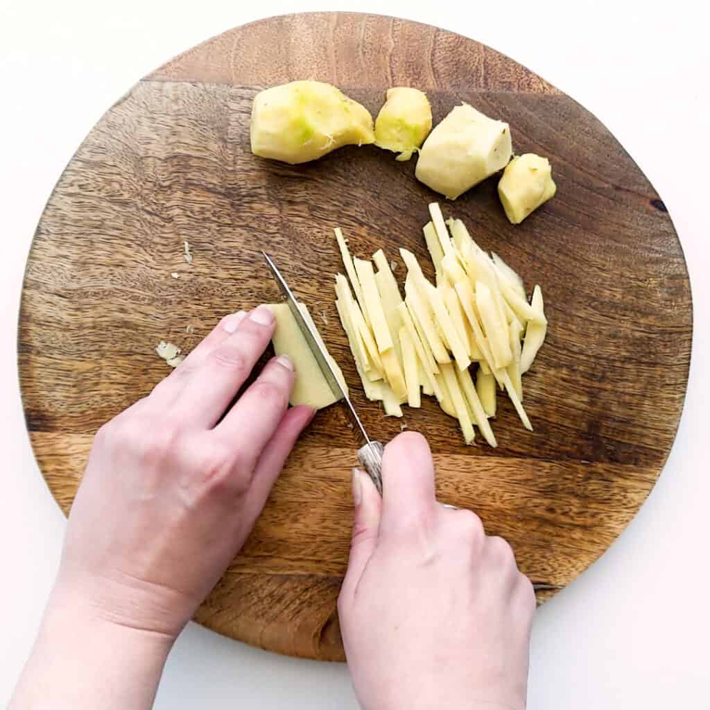 Cutting ginger into julienne strips.