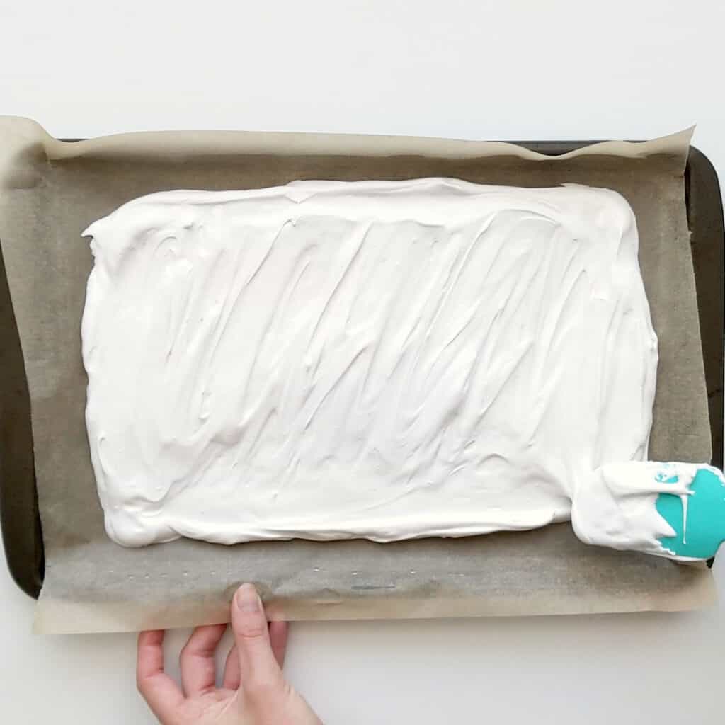 Spreading out the meringue mixture on a tray ready to bake.