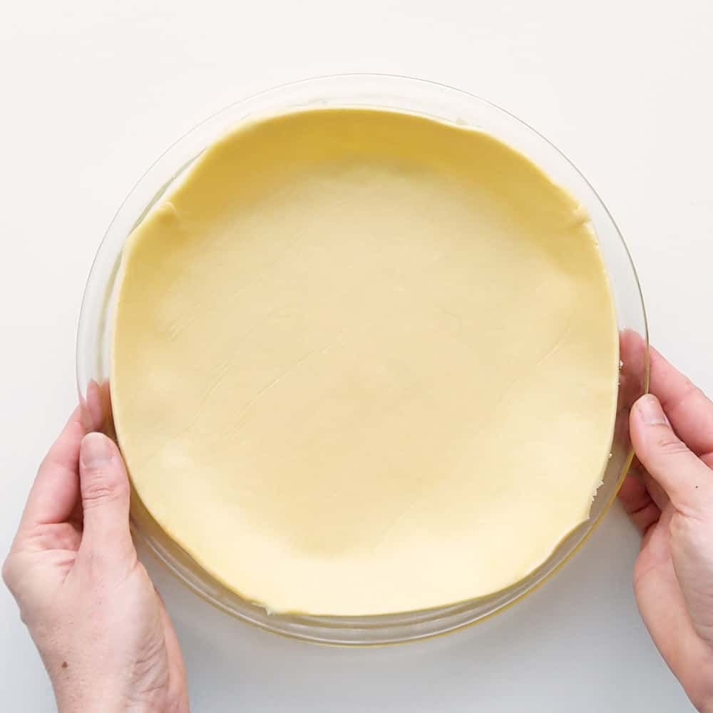 Pressing out shortcrust pastry into pie dish.