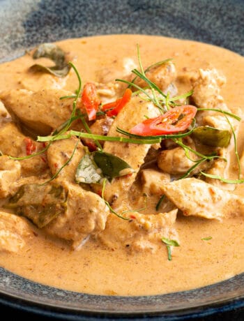 Bowl of Chicken Panang Curry topped with chilli and mukrut leaves.