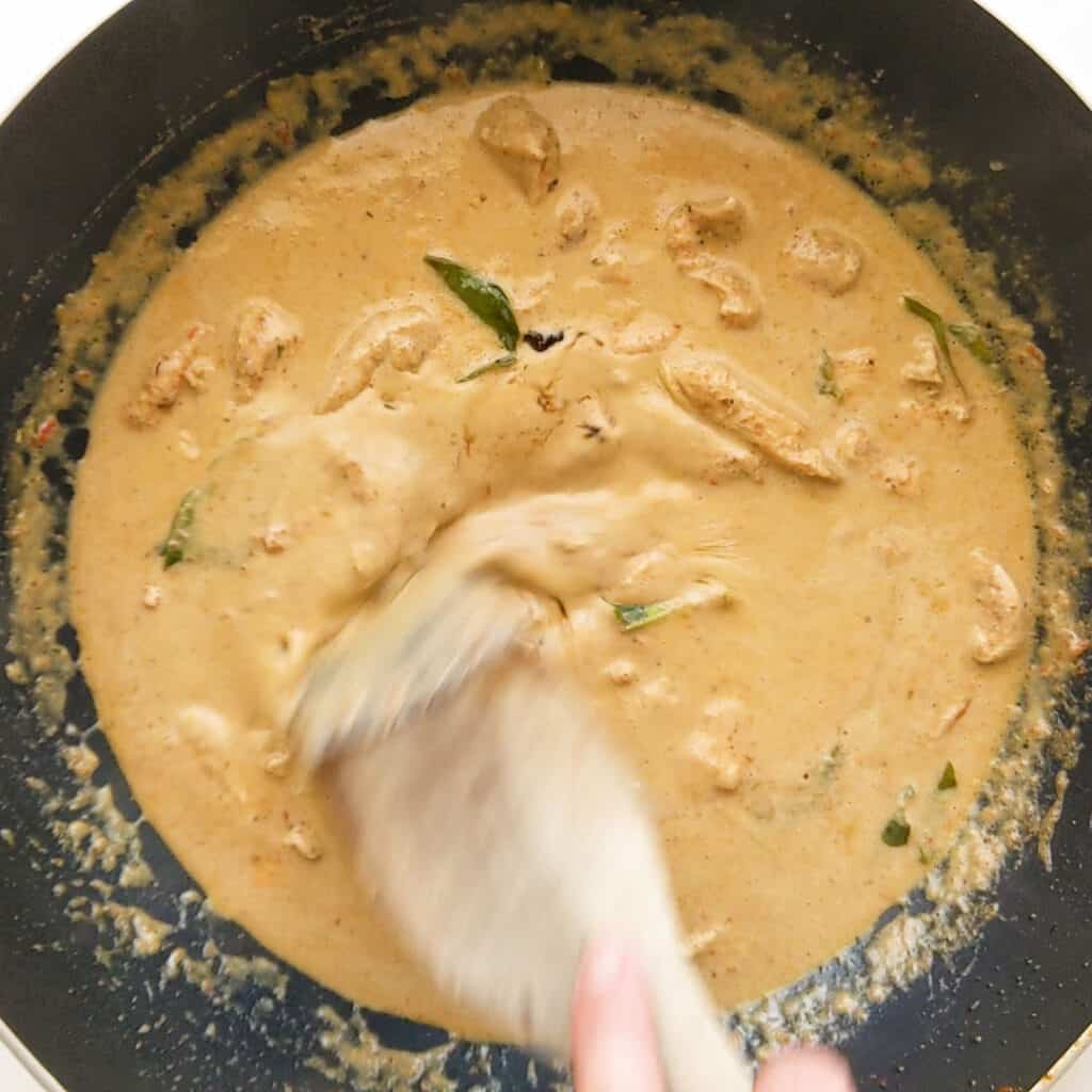 Stiring palm sugar and fish sauce into panang curry.