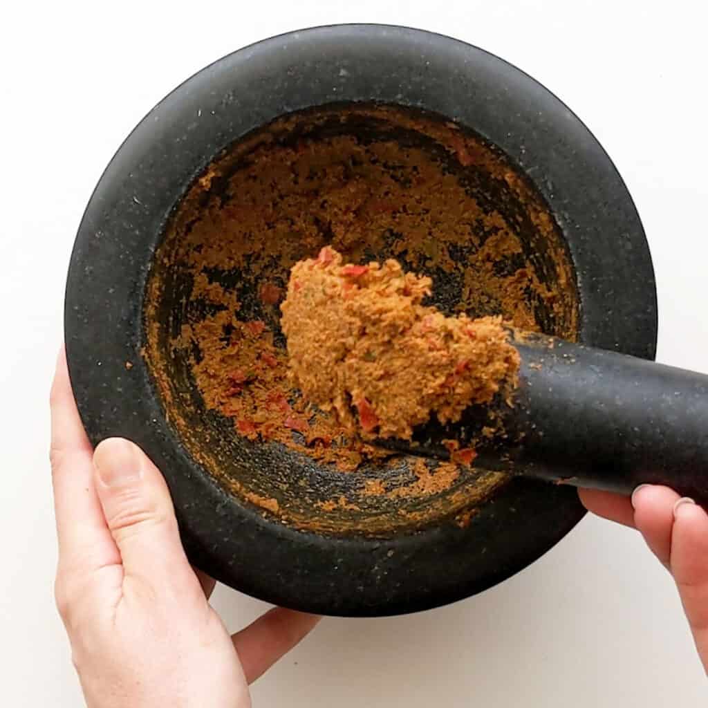 Mortar and pestle showing the texture of curry paste.