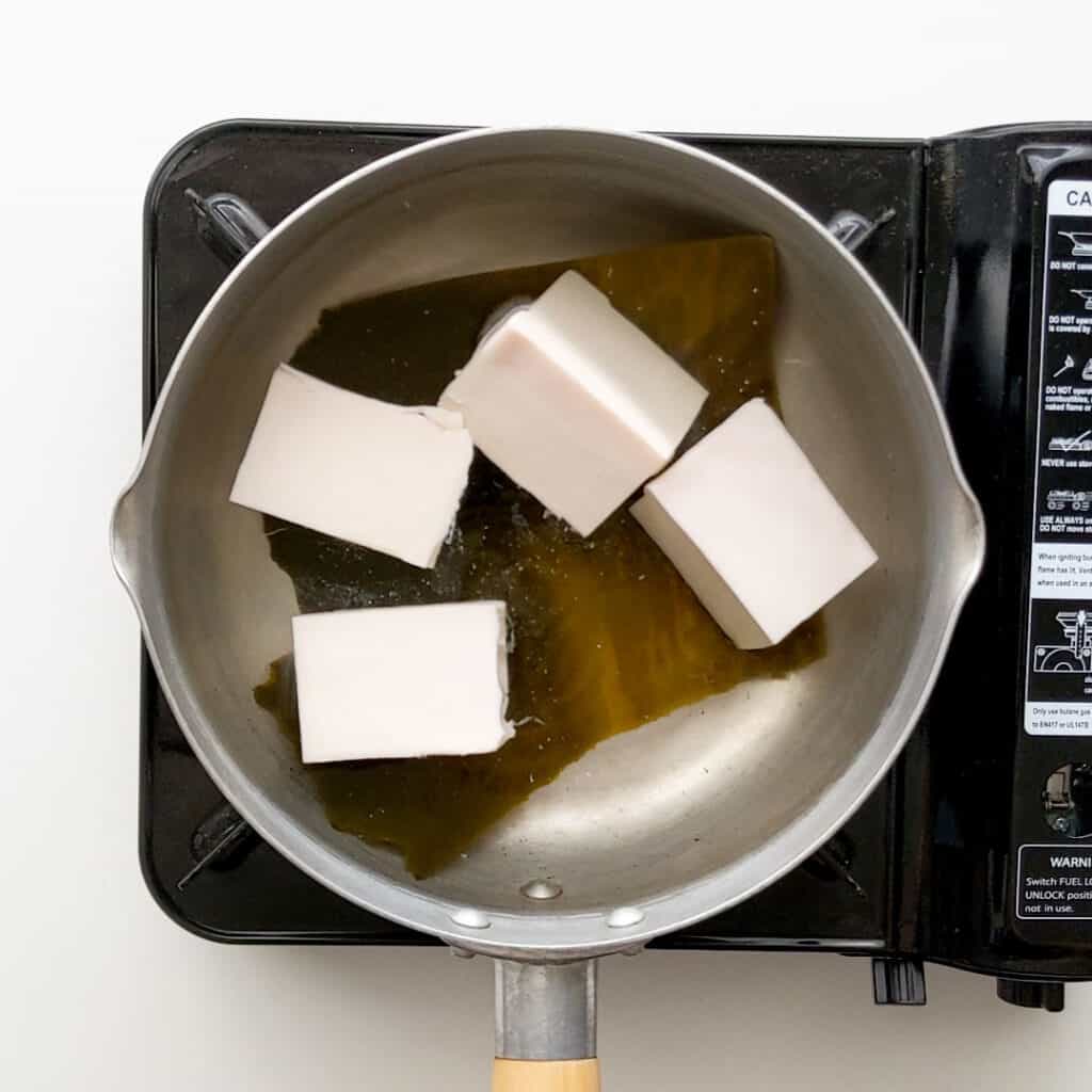 Lightly simmering tofu pieces in water.