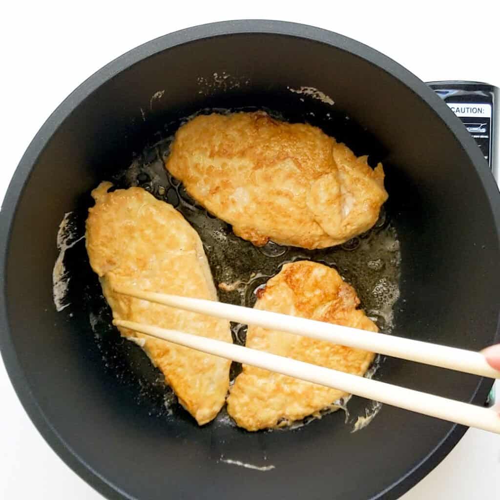 Frying the chicken in a pot.
