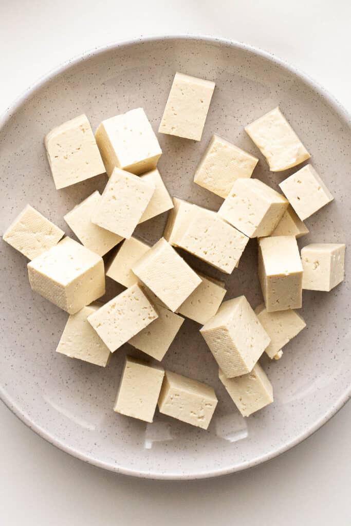 Chopped pieces of firm tofu on a plate.