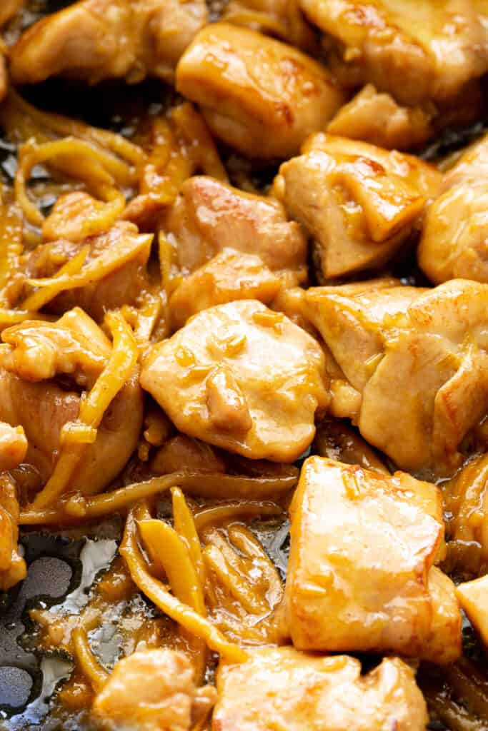 Vietnamese ginger chicken pieces stir frying in a large pan.