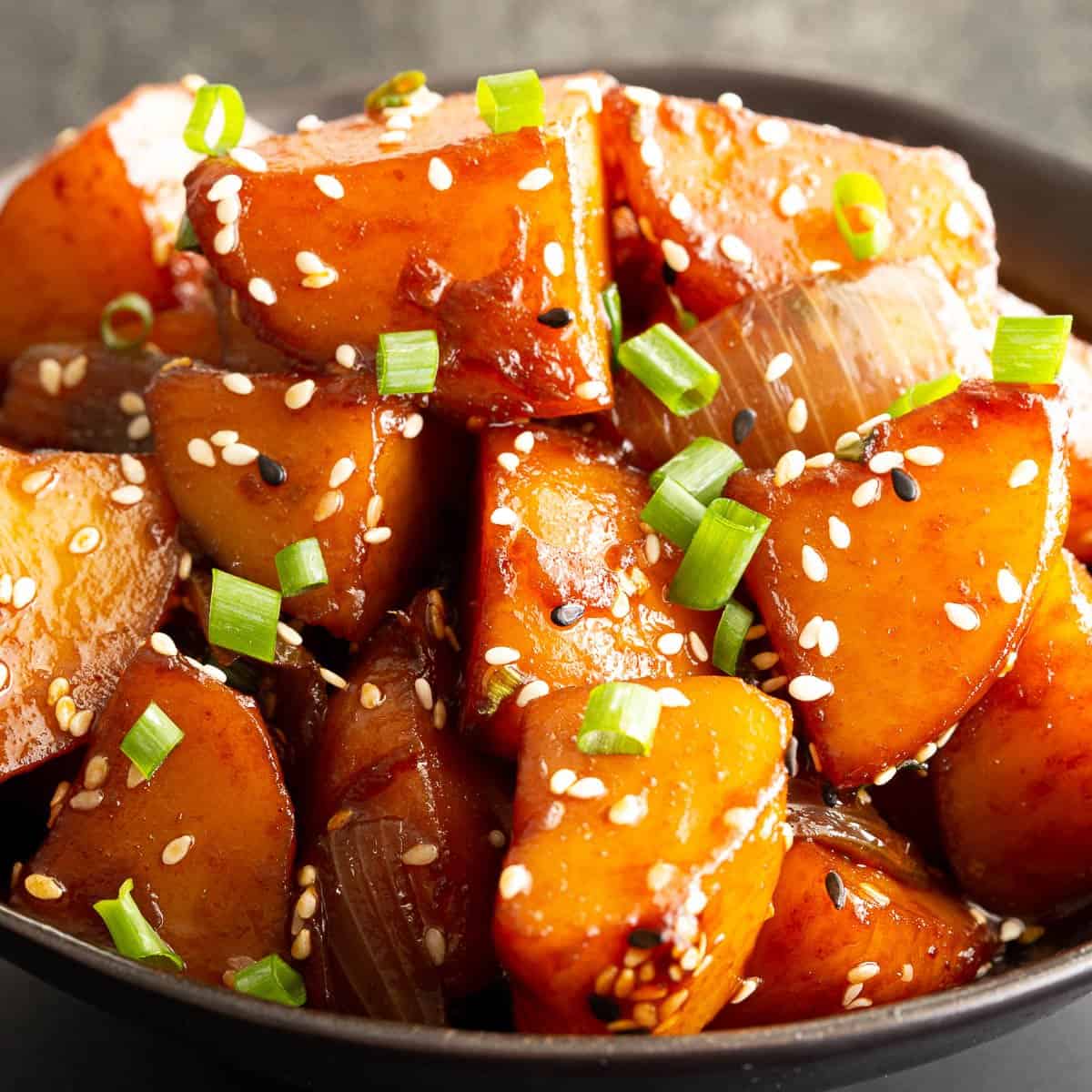 Bowl of Korean braised potatoes topped with sesame seeds.