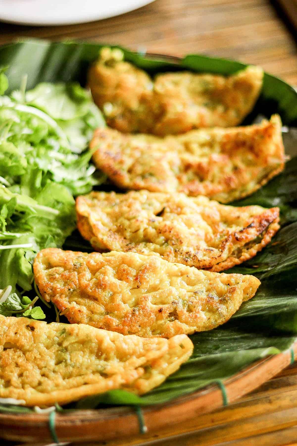 Crispy Vietnamese crepes laid out on banana leaves.