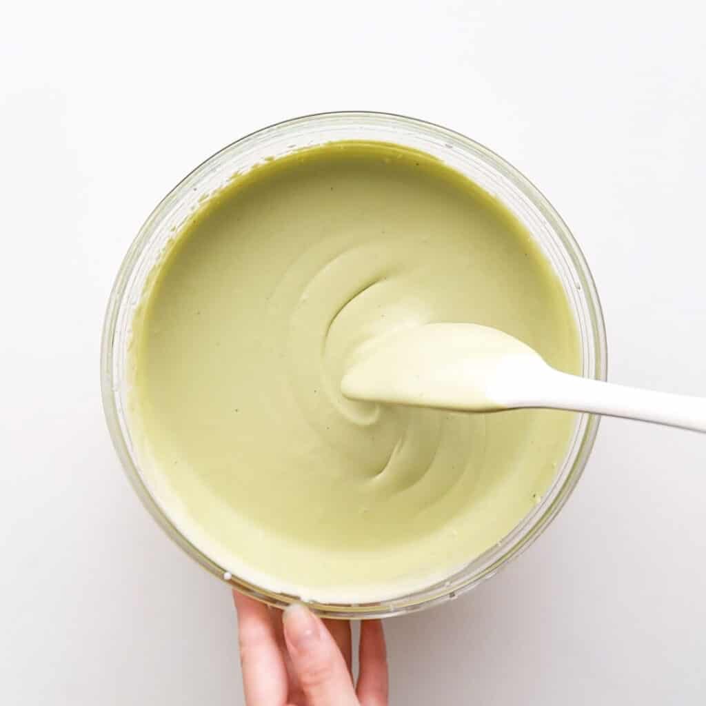 Mixing the whipped cream and sweetened matcha together.