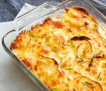 Large glass dish with golden baked potato bake.