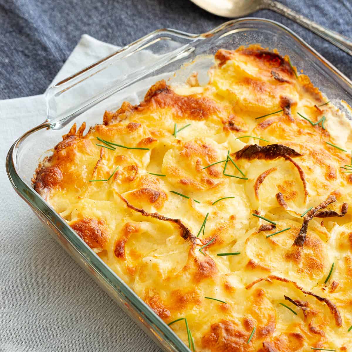 Large glass dish with golden baked potato bake.