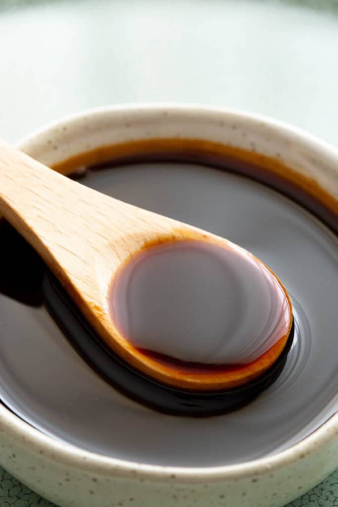 Homemade Japanese unagi sauce in a dish with a wooden spoon.