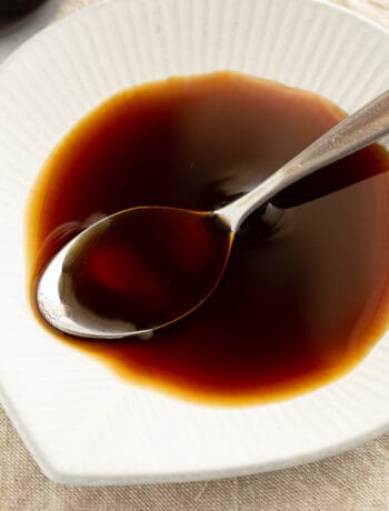 Yakitori sauce in a shallow dish with small spoon.
