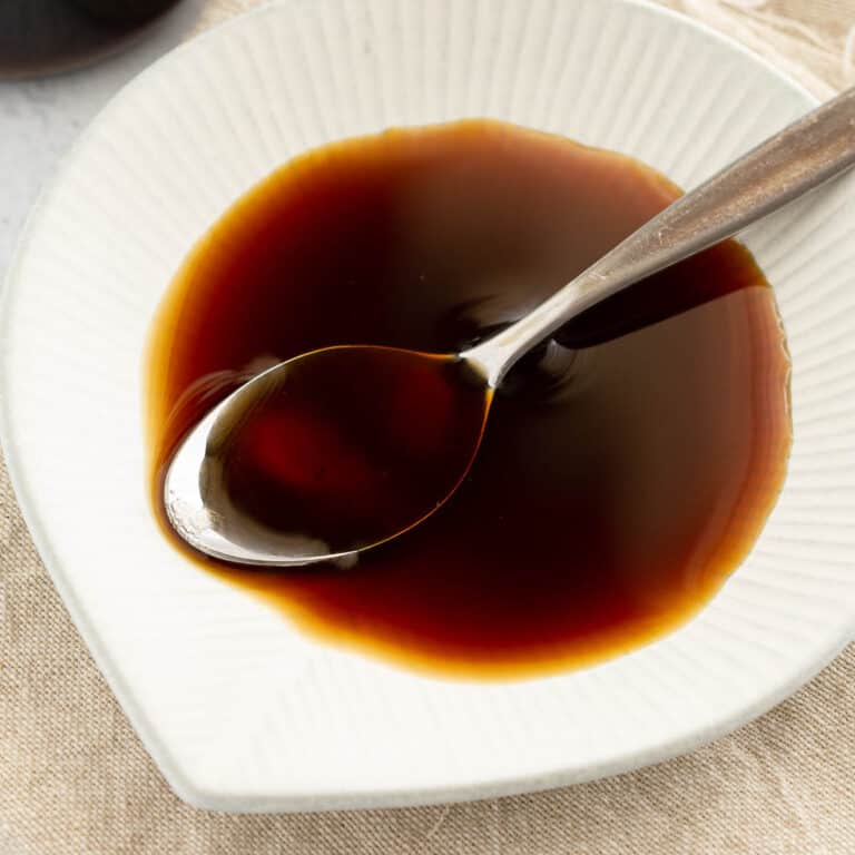 Yakitori sauce in a shallow dish with small spoon.