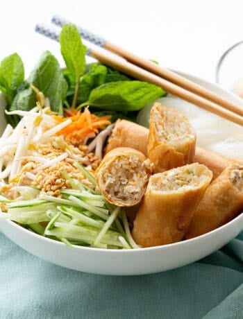 A big bowl of fresh Vietnamese noodle salad with spring rolls.