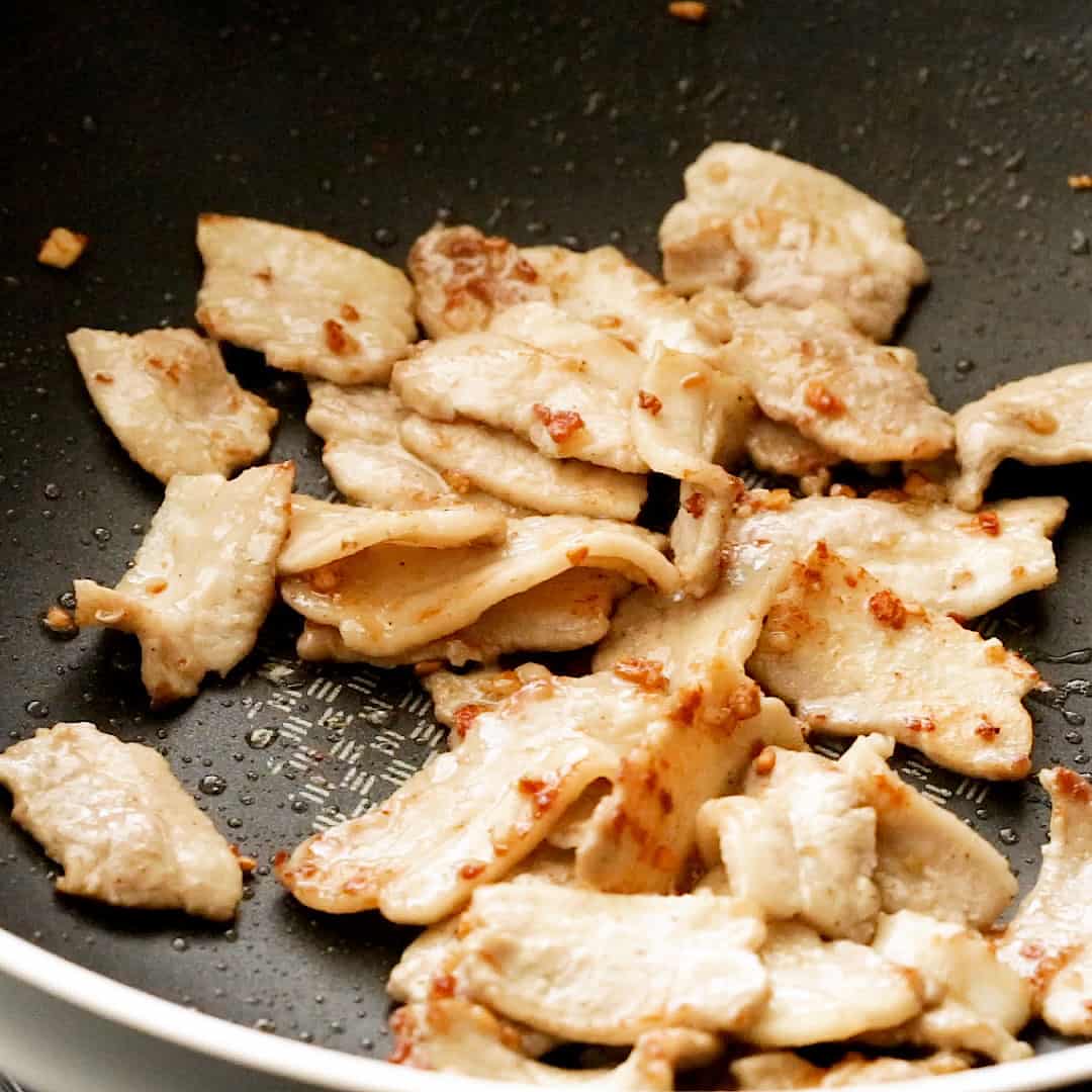 Stir fried pork belly and garlic in a pan.