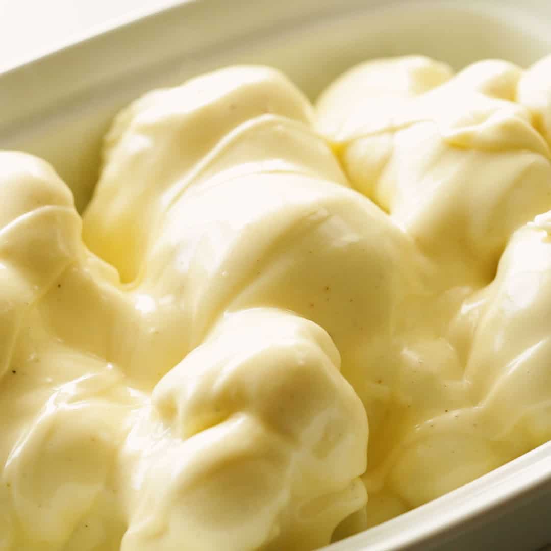 Cauliflower in a baking dish topped with cheese sauce.