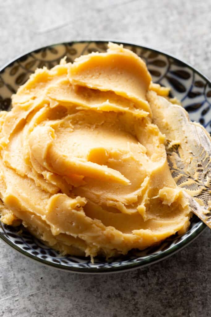 Golden butter is mixed with miso in a shallow dish.