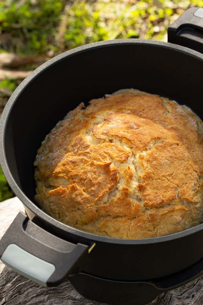 Freshly cooked damper in a remoska cooker in golden sunlight.