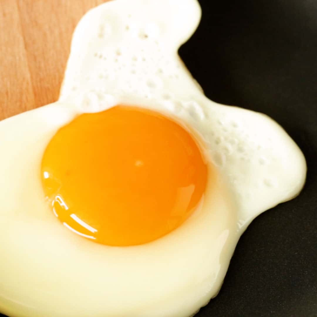 An egg being fried sunny side-up.