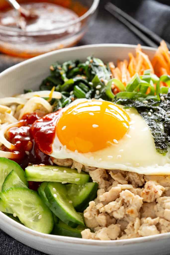 A sunny side-up egg glows on top of a Korean rice bowl.