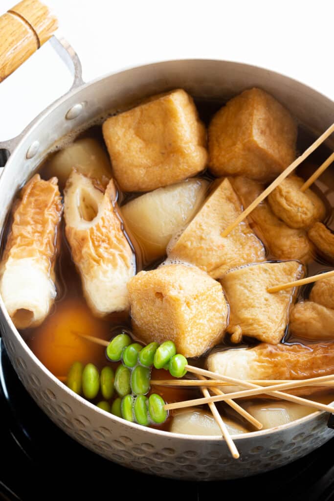 Assorted ingredients simmering in an oden hot pot.