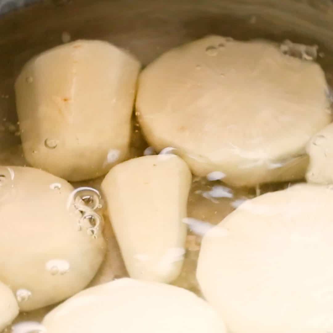 Daikon pieces cooking in water with rice.