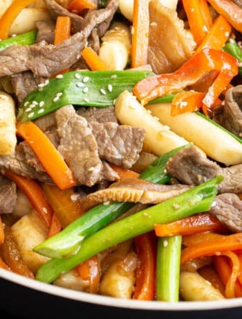 Close up shot of gungjung tteokbokki stir fry showing the cooked beef, rice cakes and vegetables.