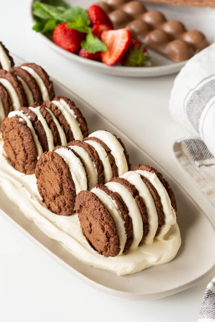 Long plate showing chocolate ripple biscuits "glued" together with whipped cream.