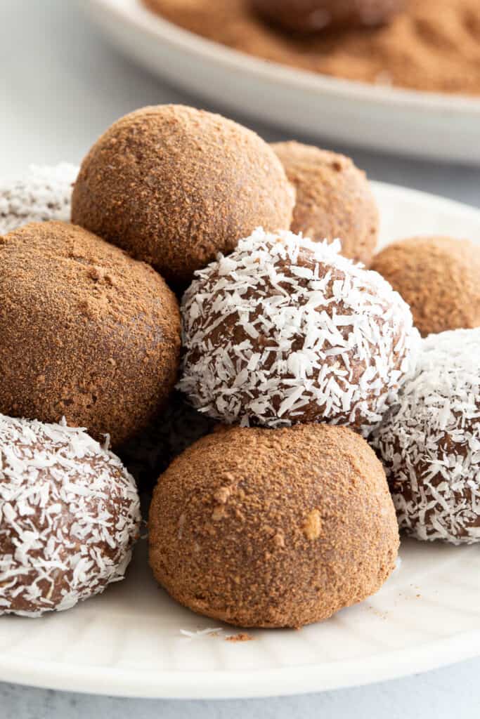 A close up of rum balls on a plate. You can see the texture of the milo and desiccated coconut. 
