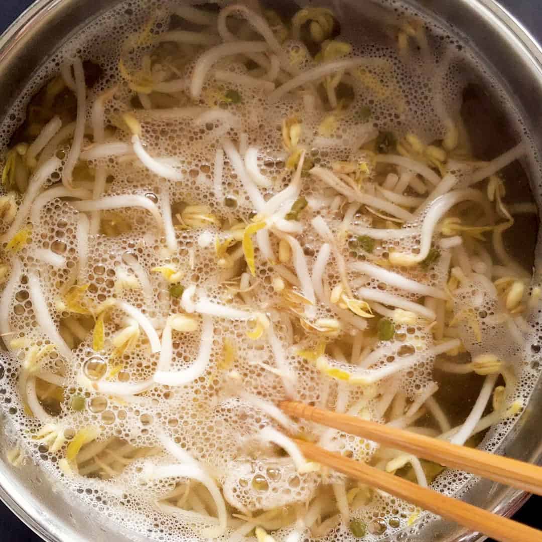 Bean sprouts simmering in a pot of dashi stock.