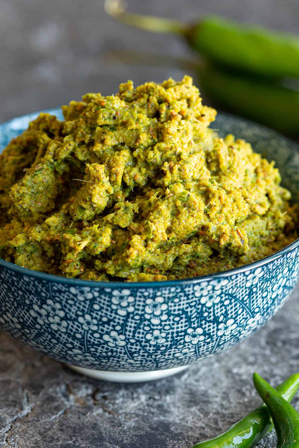 A small blue bowl piled high with Thai green curry paste.
