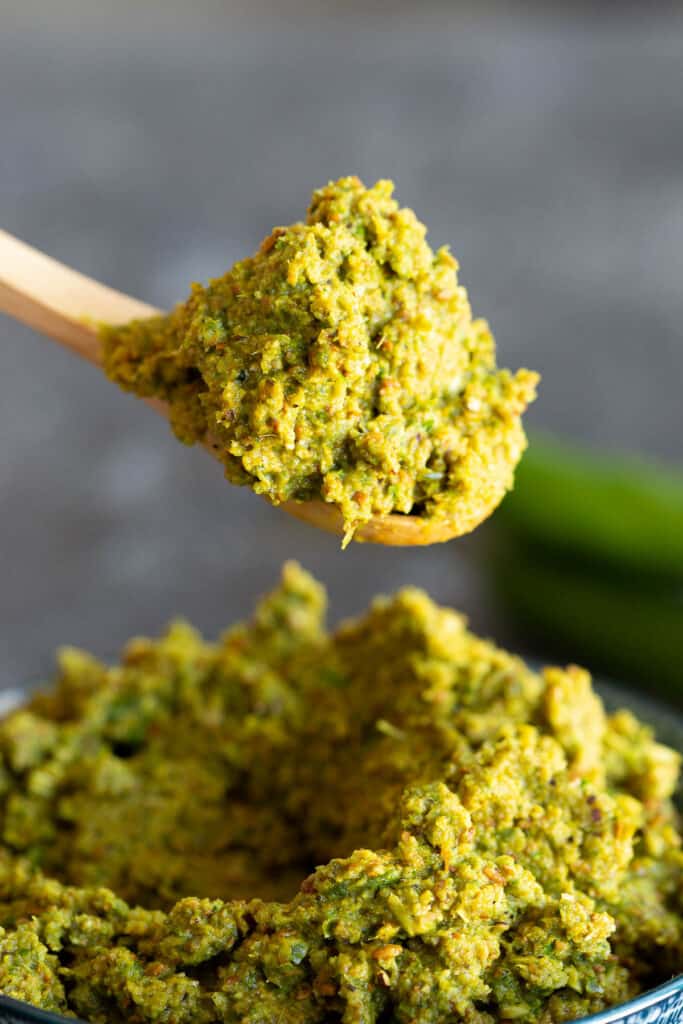 A spoon takes a big heap of green curry paste, ready to make dinner.