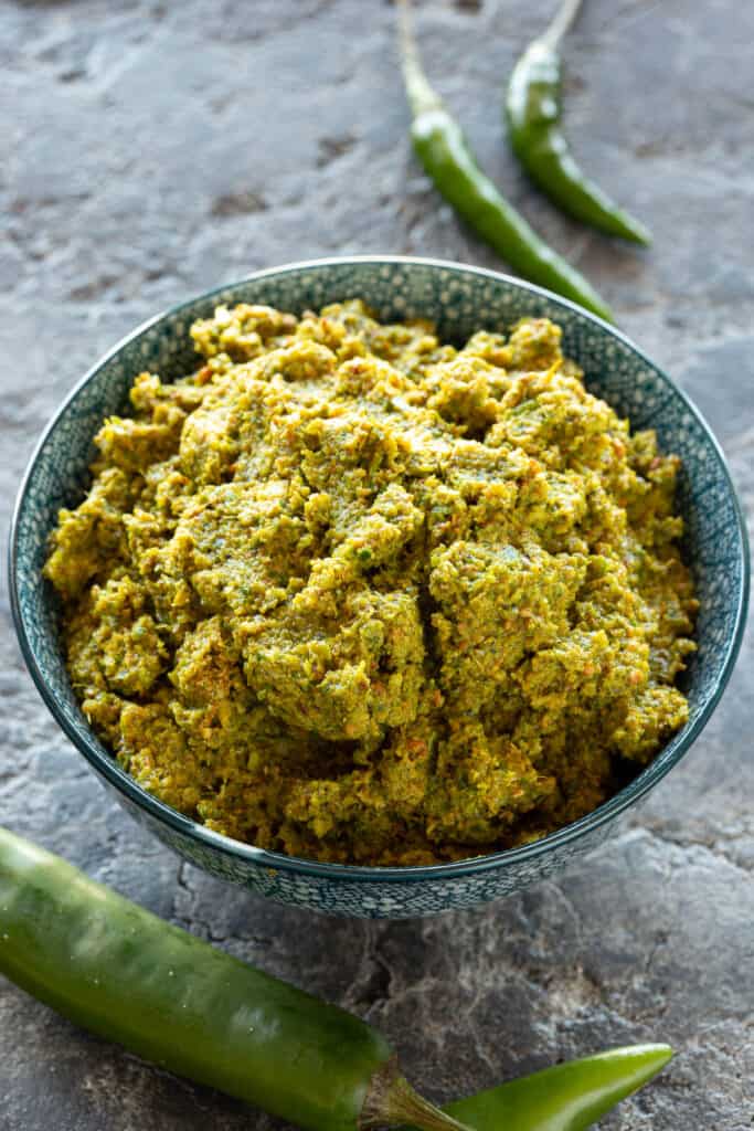 A big pile of fresh Thai green curry paste in a blue bowl.