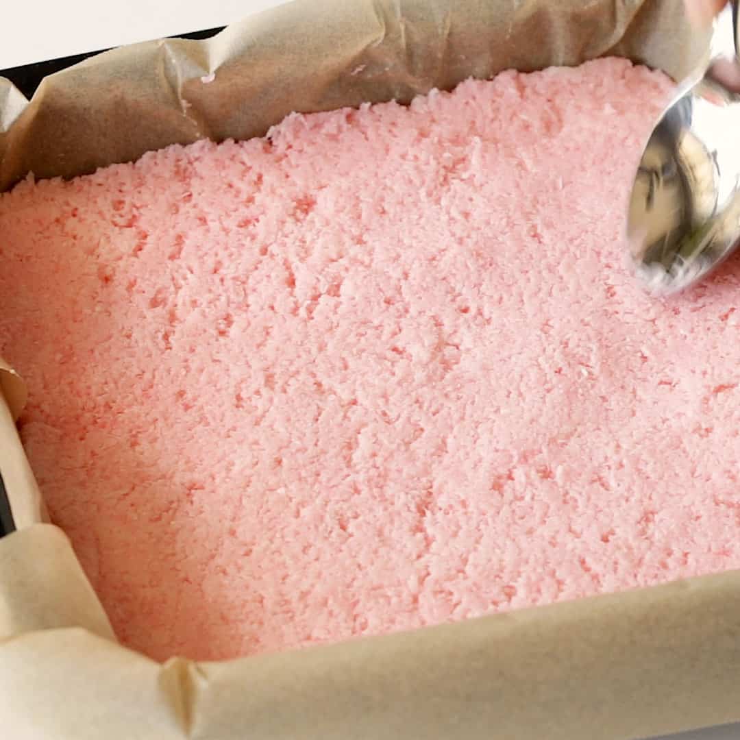 Smoothing out the pink layer of coconut.