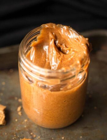 Speculoos cookie butter in a jar with crushed biscuits around the base.