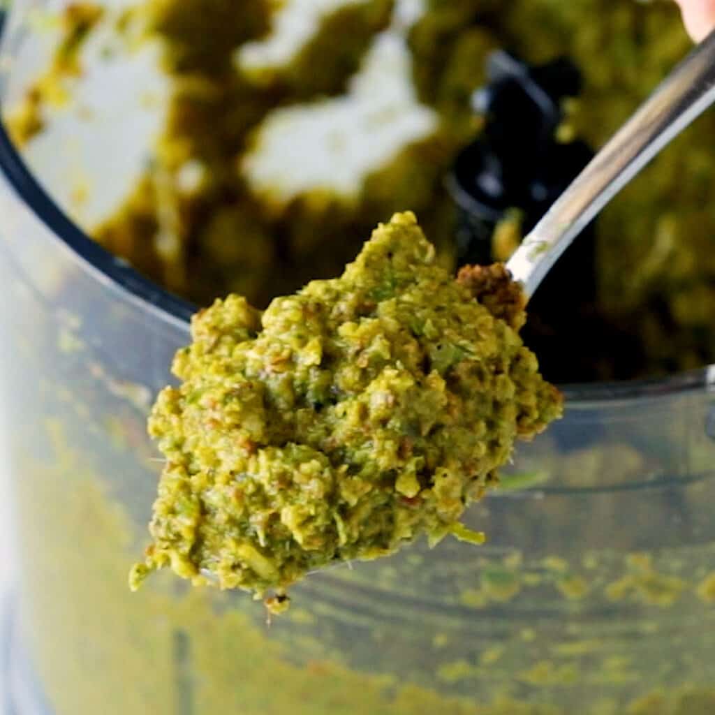 A spoonful of Thai green curry paste with the blender in the background.