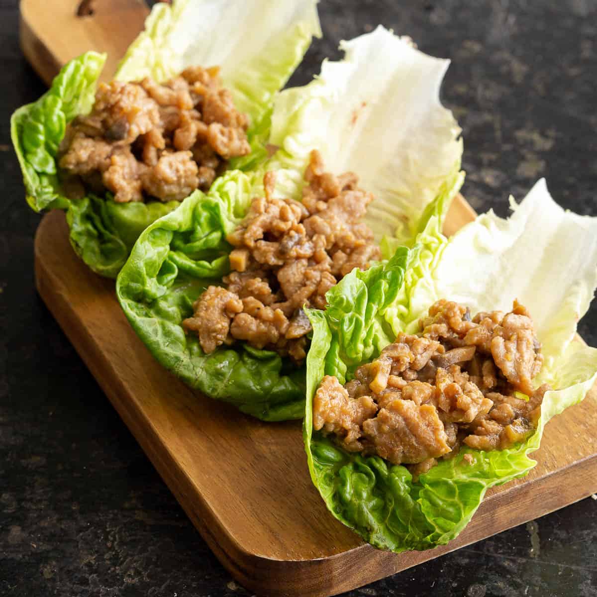 Three lettuce cups are filled with a nikumiso meat sauce.