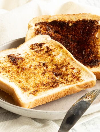 Two slices of vegemite on toast on a grey plate.
